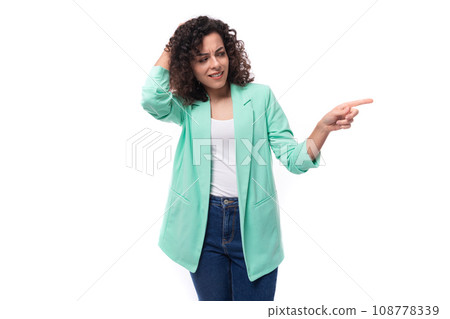 pretty young brunette curly businesswoman dressed in a blue jacket tells interesting news 108778339