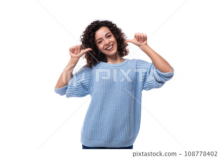 portrait of a slim young pretty lady with black curly hair dressed in a light blue sweater portrait of a slim young pretty lady with black curly hair dressed in a light blue sweater 108778402