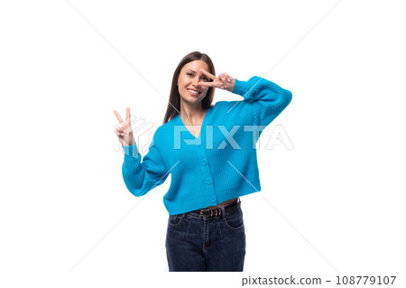 young positive pretty caucasian woman with black hair is dressed in a stylish blue cardigan and 108779107