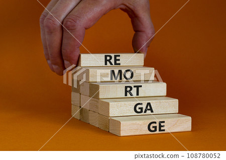 Remortgage loan symbol. Wooden blocks with the word Remortgage. Beautiful orange background, copy space. Businessman hand. Business, remortgage loan concept. Remortgage loan symbol. Wooden blocks with the word Remortgage. Beautiful orange background, copy space. Businessman hand. Business, remortgage loan concept. 108780052