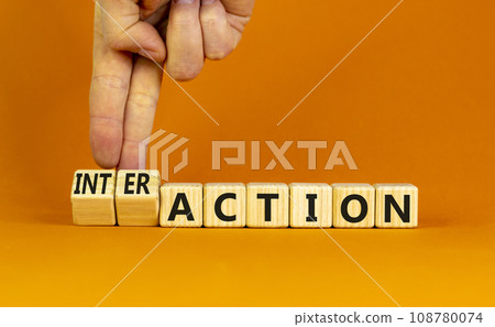 Action or interaction symbol. Businessman turns wooden cubes and changes the word action to interaction. Beautiful orange background, copy space. Business and action or interaction concept. 108780074