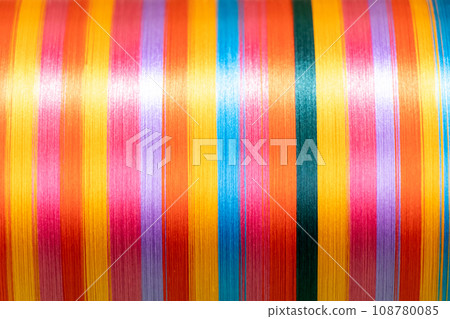 Closed up of multicolor (orange, yellow, red, blue,black,violet) of thread textured background (Focus at center of picture) 108780085