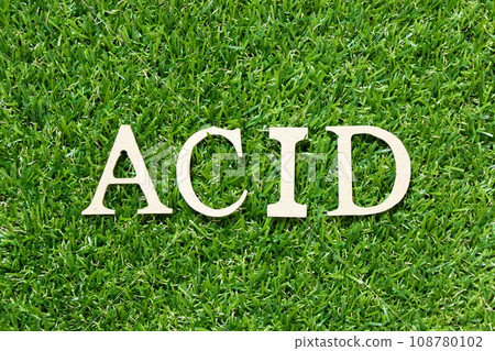 Wood letter in word acid on green grass background 108780102