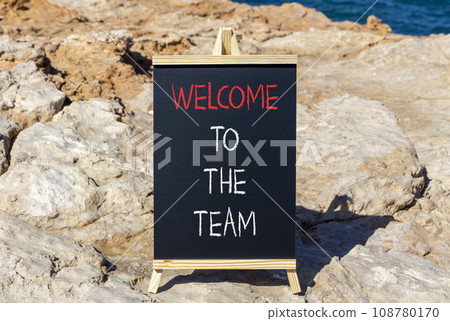 Welcome to the team symbol. Concept words Welcome to the team on beautiful black chalk blackboard. Beautiful red stone blue sea background. Business, motivational and welcome to the team concept. Welcome to the team symbol. Concept words Welcome to the team on beautiful black chalk blackboard. Beautiful red stone blue sea background. Business, motivational and welcome to the team concept. 108780170