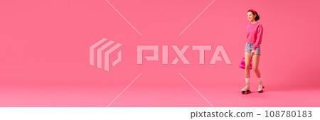 Banner. Smiling pretty woman, model dressed fashion bright outfit with modern accessories and posing have fun rollerblading isolated pink studio background. Banner. Smiling pretty woman, model dressed fashion bright outfit with modern accessories and posing have fun rollerblading isolated pink studio background. 108780183