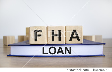 FHA loan symbol. Wooden blocks form the words 'FHA loan', book, wooden table. Beautiful white background, copy space. Business and FHA - federal housing administration loan concept. FHA loan symbol. Wooden blocks form the words 'FHA loan', book, wooden table. Beautiful white background, copy space. Business and FHA - federal housing administration loan concept. 108780268