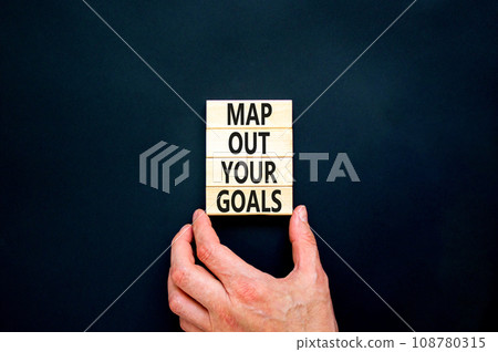 Support and map out your goals symbol. Concept words Map out your goals on wooden blocks on beautiful black table black background. Businessman hand. Business, support and map out your goals concept Support and map out your goals symbol. Concept words Map out your goals on wooden blocks on beautiful black table black background. Businessman hand. Business, support and map out your goals concept 108780315