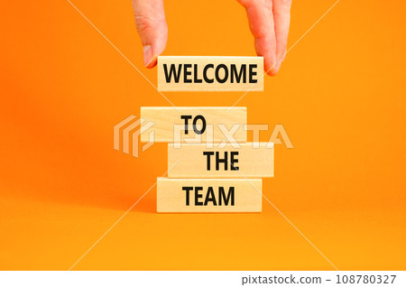 Welcome to the team symbol. Concept words Welcome to the team on wooden block. Beautiful orange table orange background. Businessman hand. Business, motivational and welcome to the team concept. Welcome to the team symbol. Concept words Welcome to the team on wooden block. Beautiful orange table orange background. Businessman hand. Business, motivational and welcome to the team concept. 108780327