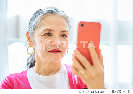 Senior woman looking at smartphone screen 108781666