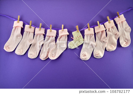 World Prematurity day concept. Normal size and tiny socks on rope on purple background 108782177