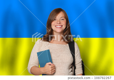 Happy woman student against Ukrainian flag background. Travel, education and learn language 108782267