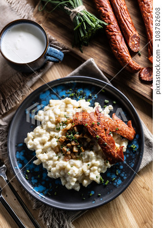 Halusky as traditional Slovak potato gnocchi with sheep cheese bryndza, fried bacon,sausage and chives Halusky as traditional Slovak potato gnocchi with sheep cheese bryndza, fried bacon,sausage and chives 108782608