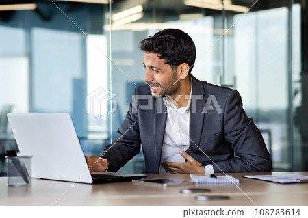 Sick Arab office worker. Stomach pain, feeling of stomach cramps while working at laptop, constipation or heartburn. Acute discomfort, digestive problems, sharp abdominal pain. Unpleasant feeling. 108783614