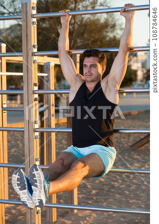 Man holding L-sit on wall bars 108784646