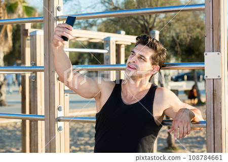 sporty man taking selfie on beach fitness station 108784661