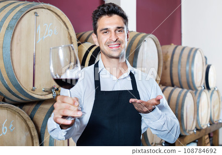 Man having glass with wine sample in alcohol section 108784692