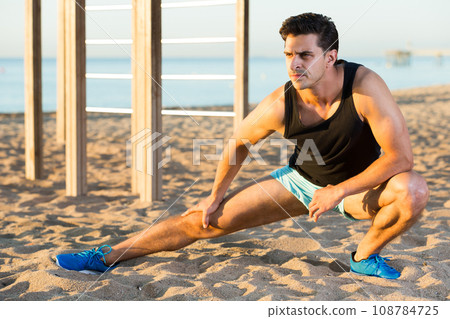 Male athlete stretching legs 108784725