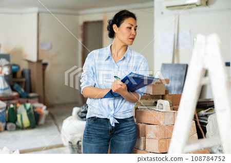 Woman making notes at renovating house 108784752