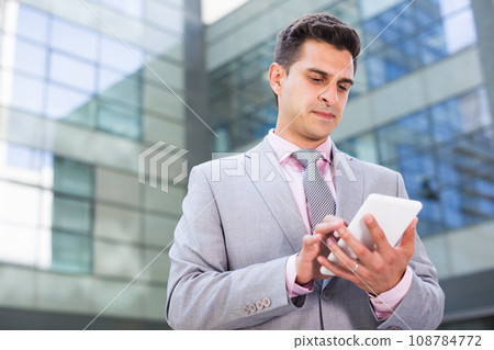 Successful businessman using phone Successful businessman using phone 108784772