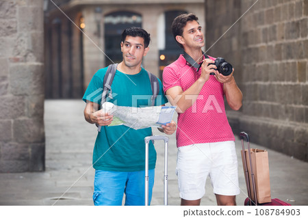 Tourists are photographing and searching way in map 108784903