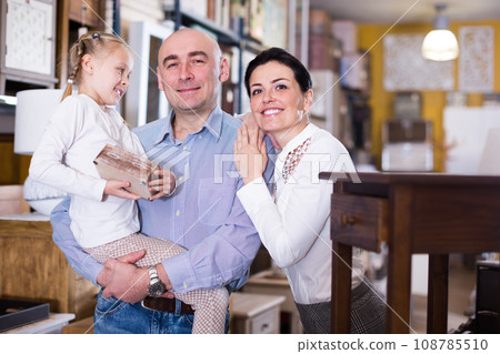 Family with daughter in specialised furniture showroom Family with daughter in specialised furniture showroom 108785510
