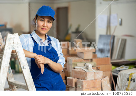 Female builder posing on indoor construction site 108785555