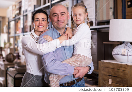 man and woman with child is in furniture store 108785599