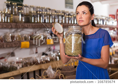 adult female take a smell natural dried herbs sold by weight in eco shop adult female take a smell natural dried herbs sold by weight in eco shop 108785674