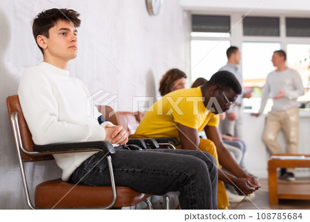 Portrait of a young man sitting waiting Portrait of a young man sitting waiting 108785684