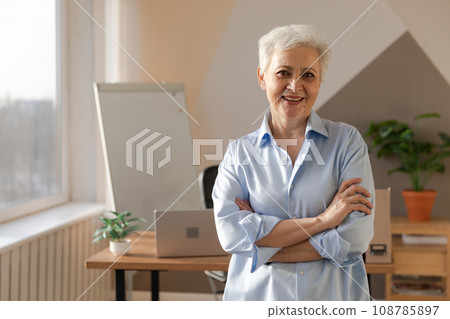 Portrait of confident stylish european middle aged senior woman at workplace. Stylish older mature 60s gray haired lady businesswoman in modern office. Boss leader teacher professional worker Portrait of confident stylish european middle aged senior woman at workplace. Stylish older mature 60s gray haired lady businesswoman in modern office. Boss leader teacher professional worker 108785897