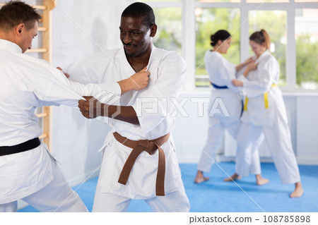 Middle-aged male judo practitioner engaged in wrestling in sports hall 108785898