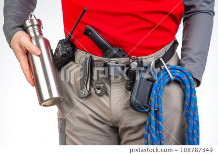 walkie-talkie, flashlight, knife, GPS navigator, climbing rope on the belt of the tourist trekking walkie-talkie, flashlight, knife, GPS navigator, climbing rope on the belt of the tourist trekking 108787349
