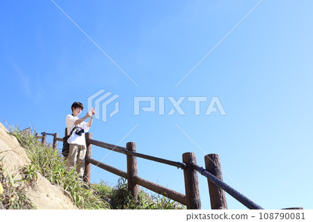 一個男人在藍天下拍照 一個男人在藍天下拍照 108790081