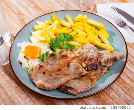 Pork chop with scrambled eggs 108790932