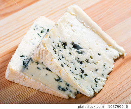 Slices of soft blue cheese with mold at plate, nobody 108790946