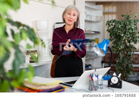 Mature woman meeting visitors at office Mature woman meeting visitors at office 108791688