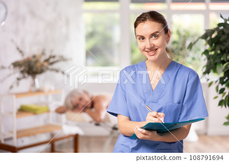 Young woman masseuse makes notes in spa salon Young woman masseuse makes notes in spa salon 108791694