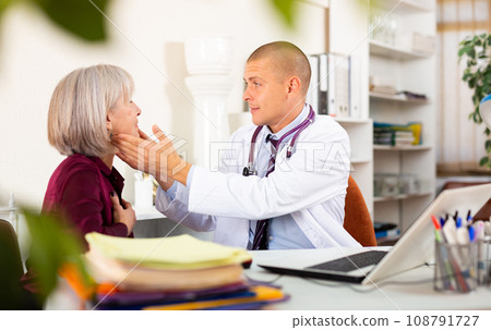 Therapist examining female patient complaining of sore throat 108791727