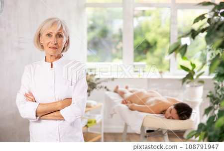 Elderly woman masseuse posing in spa salon Elderly woman masseuse posing in spa salon 108791947