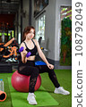 lifting a dumbbell to work the muscles in his bicep. 108792049