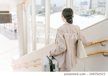 一名婦女提著沉重的行李走上樓梯(車站/機場) 一名婦女提著沉重的行李走上樓梯(車站/機場) 108792425