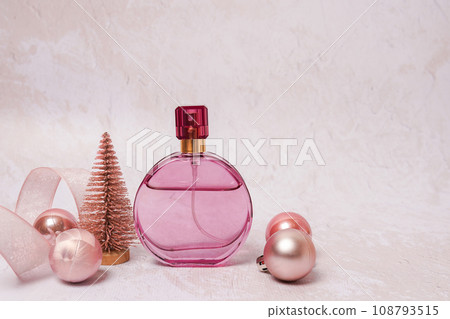 Christmas composition with perfume bottle on light concrete background Christmas composition with perfume bottle on light concrete background 108793515