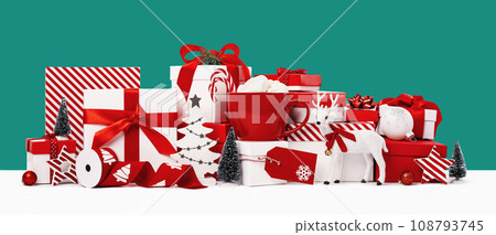 Big pile of assorted red and white gift boxes and ornaments with Christmas trees on blue green background. Assorted size. Merry Christmas and Happy New Year gift shopping and sale concept Big pile of assorted red and white gift boxes and ornaments with Christmas trees on blue green background. Assorted size. Merry Christmas and Happy New Year gift shopping and sale concept 108793745