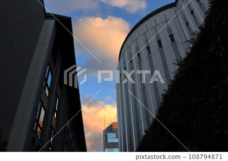 日落時在建築物之間看到的雲 108794871
