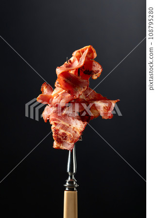 Roasted bacon on a fork. Roasted bacon on a fork. 108795280