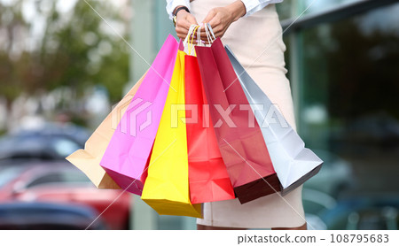 Female standing near dress store holding 108795683