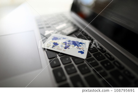 White plastic credit card lie on black laptop 108795691