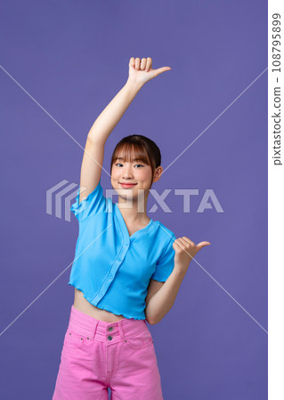 young pretty woman smiling cheerfully and casually pointing to side, feeling happy and satisfied 108795899