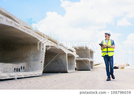 Professional senior Asian civil engineer working at the heavy infrastructure construction site, civil engineer - foreman inspecting the segmentation construction bridge. Professional senior Asian civil engineer working at the heavy infrastructure construction site, civil engineer - foreman inspecting the segmentation construction bridge. 108796039