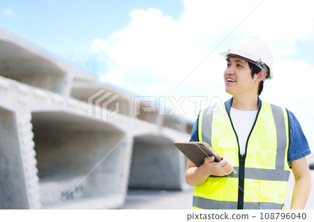 Professional senior Asian civil engineer working at the heavy infrastructure construction site, civil engineer - foreman inspecting the segmentation construction bridge. 108796040